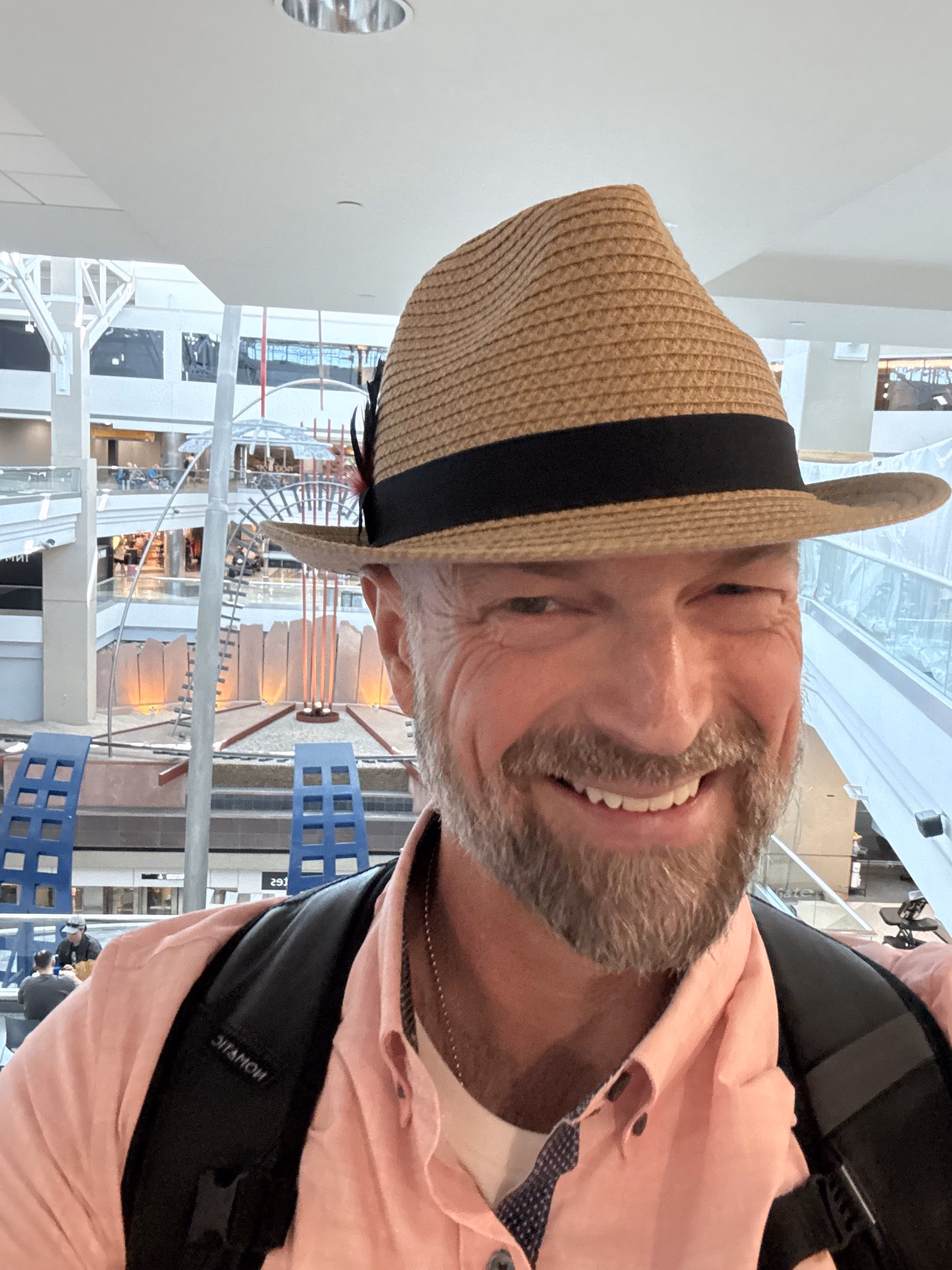 Niels in a straw hat with a big grin, on his way somewhere